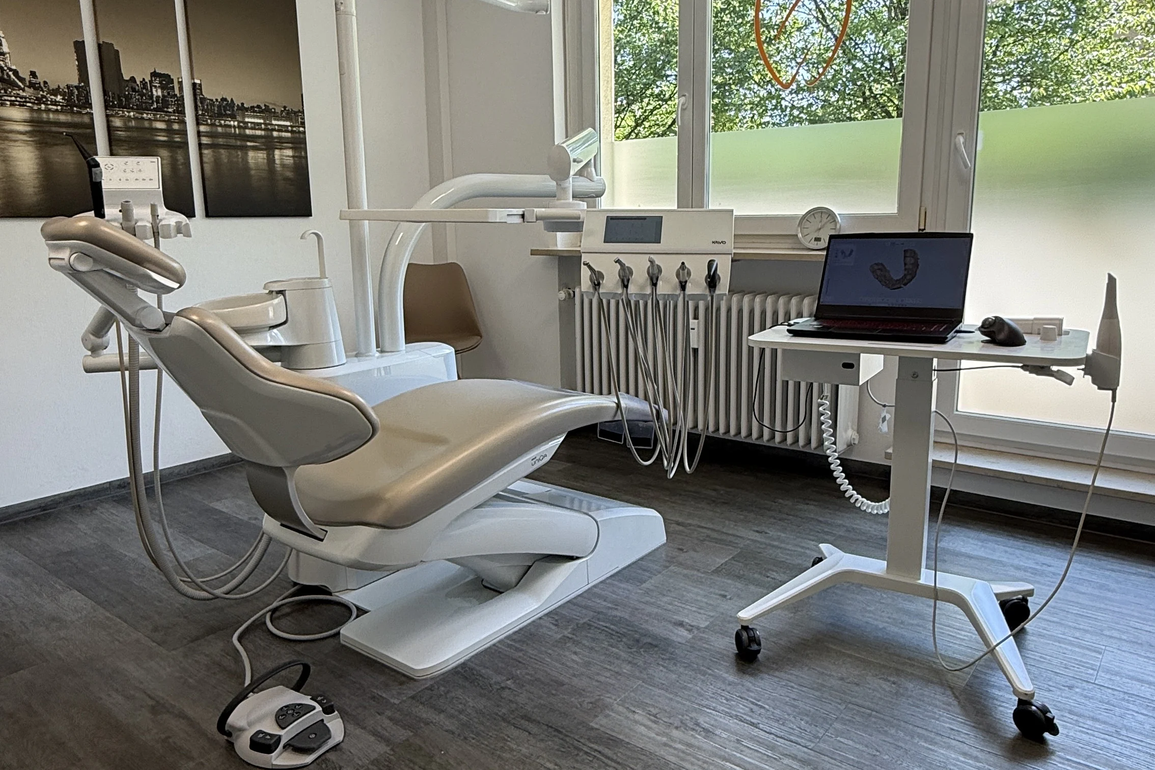 Helles Behandlungszimmer mit breiter Fensterfront und modernem Behandlungsstuhl